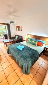 a bedroom with a large bed and a couch at Rainforest Motel, Mission Beach in Mission Beach +32 photos