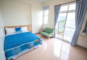 una camera da letto con un letto, una sedia e una finestra di Sally's Home a Città Vecchia di Hengchun