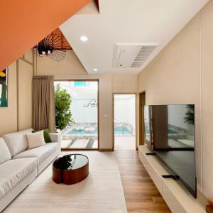 a living room with a couch and a large tv at Swan Private Pool Villa Bangsaen in Ban Thai Don (1)
