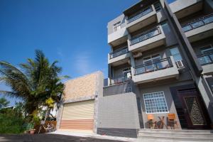 un edificio con una palma di fronte di Sally's Home a Città Vecchia di Hengchun