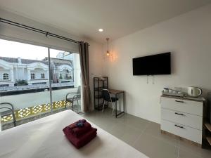 a bedroom with a bed and a flat screen tv at Inn Dulgence in Patong Beach