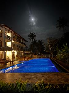 a swimming pool at night with the moon in the sky at Hotel Siyomin in Ahangama