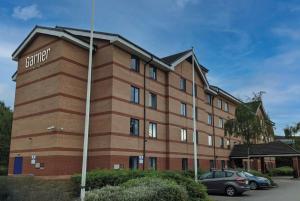 a brown brick building with a sign on it at Garner Hotel Lincoln by IHG in Lincoln