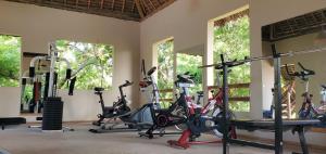 a gym with several treadmills and exercise bikes at Promised Land Lodge in Kizimkazi