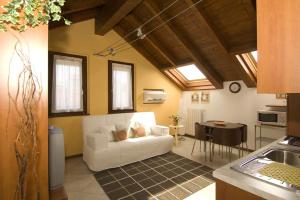 メレニャーノにあるAppartamenti Villa Annaのリビングルーム(白いソファ、テーブル付)