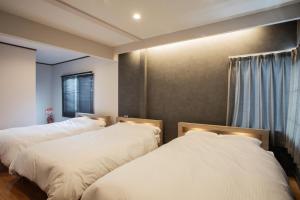 a bedroom with two beds and a window at 禅ーZen Villa Hakodate in Hakodate