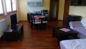 a living room with a table and chairs and a kitchen at Guest House Mladosť in Prešov