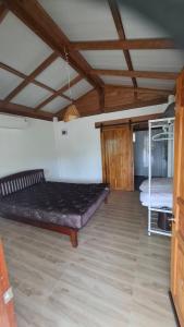 a room with two beds and a wooden ceiling at Anna Garden Homestay in Ban Phlu Kom