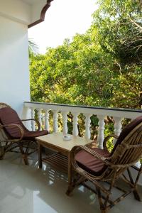 a patio with two chairs and a table on a balcony at Eve Resort in Patnem