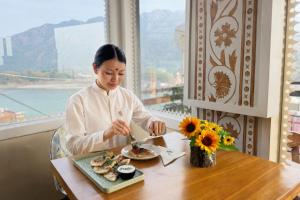 a woman sitting at a table with a plate of food at Sanskriti Vedic Retreat in Rishīkesh