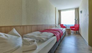 a hotel room with a bed and red chairs at RÜGEN-HOTEL mit Ostseeblick in Sassnitz +78 photos