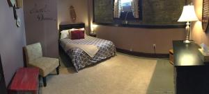 a bedroom with a bed and a chair in it at Morguen Toole in Meyersdale