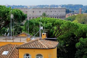 a yellow building with a large building in the background at Mecenate Charme Apartment in Rome