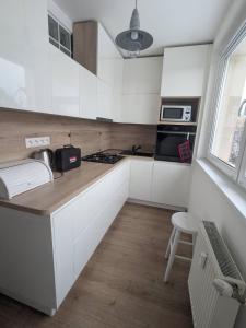 a kitchen with white cabinets and a counter top at Summit Suite in Vysoké Tatry
