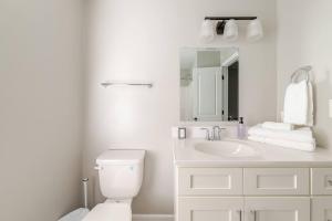 a white bathroom with a toilet and a sink at Litorum - a place to land, breathe, and reset in Front Royal +52 photos