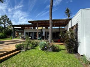 a house with a patio and a palm tree at Maison Nature in La Possession