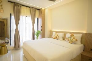 a bedroom with a large white bed and a window at 3 Raahi Varanasi in Varanasi