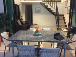 a table with chairs and a table with flowers on it at Blue Moon House in Ko Samed