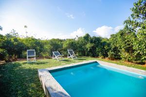 an image of a swimming pool in a yard with two chairs at Cinnamon Legacy in Weligama