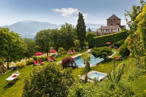 un jardin avec une piscine et un bâtiment en arrière-plan dans l'établissement Schloss Hotel Korb, à Appiano sulla Strada del Vino