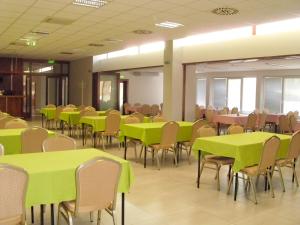 una sala con tavoli e sedie con tavoli verdi da calce di Guest House Mladosť a Prešov