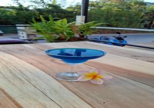 a blue glass with a flower on a wooden table at TC House and Cafe in Chiang Mai