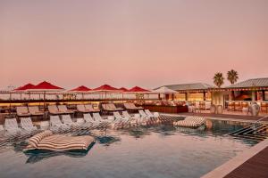 a swimming pool with lounge chairs and a resort at InterContinental Table Bay Cape Town by IHG in Cape Town