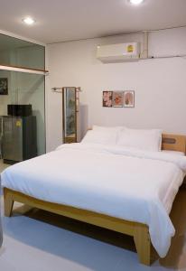 a bedroom with a large bed with white sheets at Stay Together 3BR walkable to Nimman 6 Guests in Chiang Mai