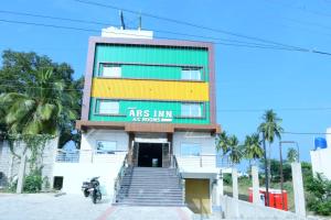 a building with a motorcycle parked in front of it at ARS INN AND MINI HALL Vellore in Vellore