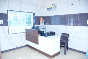 a white counter with a black chair in a room at ARS INN AND MINI HALL Vellore in Vellore