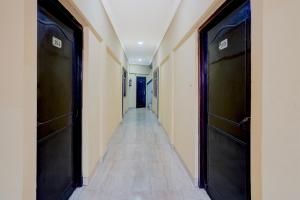 a hallway with two black doors and a tile floor at Hotel O Charbagh Metro Station Formerly Siddhi Paradise in Lucknow