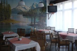 une salle à manger avec des tables, des chaises et une télévision dans l'établissement Hotel Tatrawest, à Zuberec