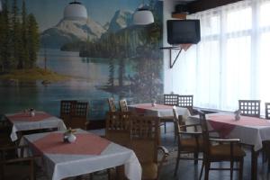 a dining room with tables and chairs and a tv at Hotel Tatrawest in Zuberec