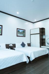 two beds in a room with white walls at Tamcoc Cloud Homestay in Ninh Binh