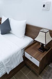 a bedroom with two beds and a lamp on a night stand at Tamcoc Cloud Homestay in Ninh Binh