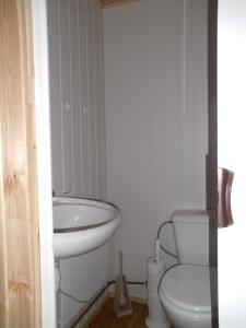 La salle de bains blanche est pourvue de toilettes et d'un lavabo. dans l'établissement Chalet Sara, à Resteigne