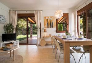 a living room with a table and chairs and a tv at Olympus Villas in Paralía Skotínis