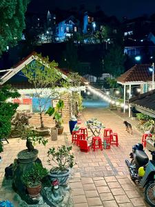 a patio with red chairs and a table and a pool at Khách sạn Hoa Chuông, trung tâm Đà Lạt in Da Lat