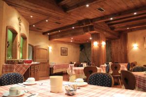 a restaurant with tables and chairs in a room at Hotel Ottoz Meublé in Courmayeur