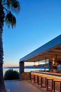a restaurant with a bar with a view of the ocean at Poseidon of Paros Hotel & Spa in Chrissi Akti