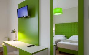 a room with two beds and a desk and a tv at Hotel Milano Palmanova in Milan