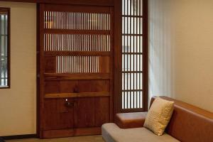 a living room with a couch and a wooden door at Boutique Stay Kanazawa Oost Knoll in Kanazawa