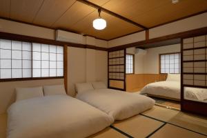 two beds in a room with windows at Boutique Stay Kanazawa Oost Knoll in Kanazawa