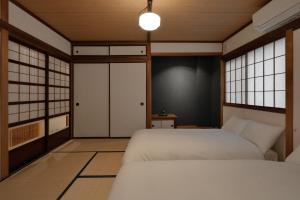 a bedroom with a bed and a door and windows at Boutique Stay Kanazawa Oost Knoll in Kanazawa