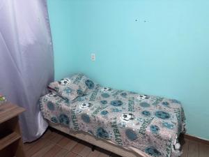 a couch with a blanket on it in a room at Praia do sonho, Quarto para até 4 pessoas super aconchegante in Palhoça +1 photo