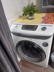 a washing machine with a plant on top of it at Praia do sonho, Quarto para até 4 pessoas super aconchegante in Palhoça