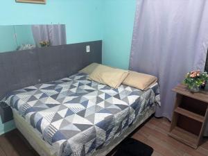 a bedroom with a bed with a blue wall at Praia do sonho, Quarto para até 4 pessoas super aconchegante in Palhoça