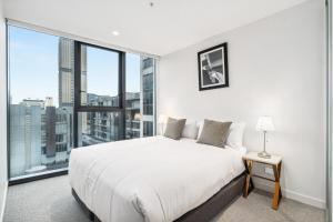 a bedroom with a white bed and a large window at Realm Apartments by CLLIX in Adelaide