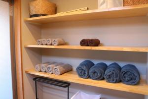 a closet with wooden shelves with rolls of towels at お子さま連れ歓迎 森のやさしいサウナ付き一棟貸し -ご家族ご夫婦限定- in Komoro +54 photos