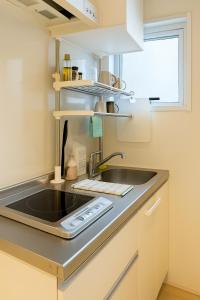 a kitchen with a sink and a stove at 旅館ほのか in Osaka +5 photos